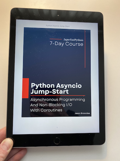 Photo of me holding my iPad with a copy of "Python Asyncio Jump-Start".